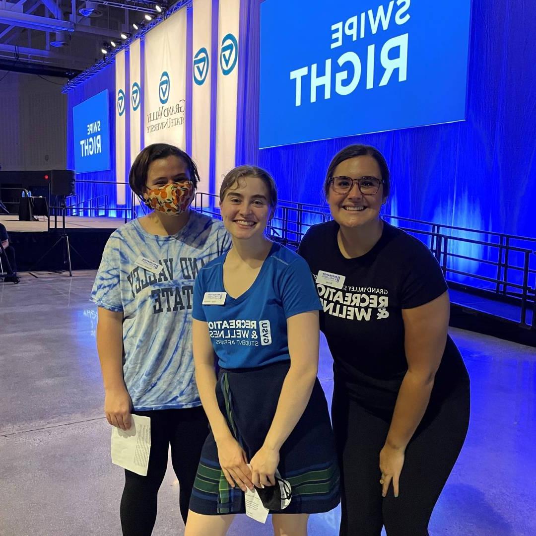 Image of three RecWell staff at Transitions event stage.